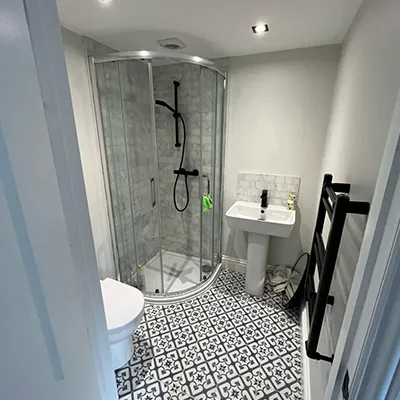 a bathroom with a walk in shower next to a sink